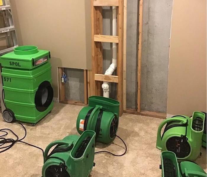  Room with wall cavity opened and SERVPRO drying equipment