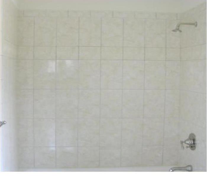 Soot on white bathroom tiles in shower
