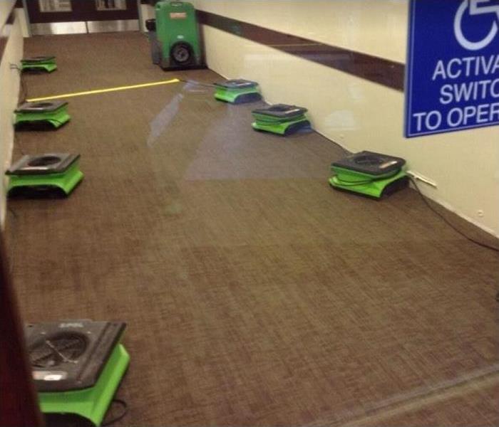 SERVPRO restoration equipment being used in hallway of water damaged business
